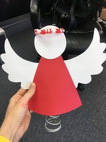 a hand holding up a paper angel decoration