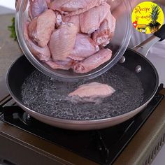 a person cooking chicken in a frying pan on top of an electric burner