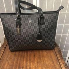 This London Fog Handbag Is Perfect For Any Woman On The Go. The Exterior Is Made Of High-Quality Faux Leather And Features A Trendy Logo Pattern In Black And Gray. The Zipper Closure Ensures The Safety Of Your Belongings And The Silver Hardware Adds A Touch Of Sophistication. Inside, There Is A Black Lining And Multiple Pockets To Keep Your Items Organized. The Medium Size Makes It Easy To Carry Around All Day Without Being Too Bulky. The Handle And Strap Are Also Made Of Faux Leather, With A St Trendy Logos, Woman Bag, Medium Handbags, London Fog, Logo Pattern, Black And Gray, Silver Hardware, Medium Size, Zipper Pocket