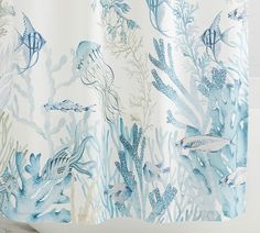 a shower curtain with blue and white sea life on it, along with corals