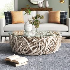 a white couch sitting next to a glass table on top of a blue area rug