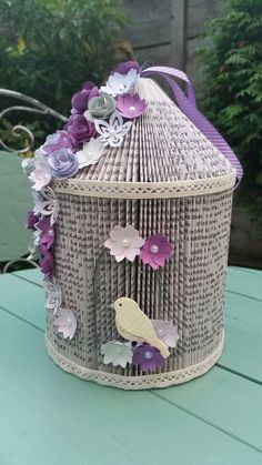 a birdcage with flowers on it sitting on a table