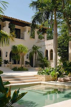 a house with a pool in front of it and palm trees around the pool area