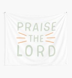 a white wall tapestry with the words praise the lord in orange and green on it