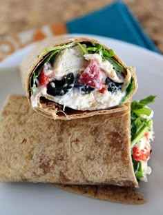 a burrito filled with fruit and veggies on top of a white plate