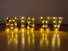 lighted letters spelling the word mis - xyv on a wooden floor