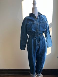 Amazing 1980s denim jumpsuit Boilersuit Big pockets Quality denim Big snap placket detail on the chest High waist Flattering fit Made by Dreams 100% cotton Size Medium - Large  Shoulder to shoulder 32" Chest 40" Waist 24-36" Hip 40" Inseam length 29" Torso length 16" Sleeve length 22" High Rise Denim Jumpsuit With Pockets In Utility Style, Vintage Cotton Denim Jumpsuit In Medium Wash, Vintage Denim Jumpsuit With Button Closure For Spring, Utility Style High Waist Cotton Denim Jumpsuit, Vintage High Rise Denim Jumpsuit, Retro Dark Wash Cotton Denim Jumpsuit, Vintage Denim Blue Cotton Jumpsuit, Utility Style Cotton Denim Jumpsuit With High Waist, Vintage Dark Wash Cotton Denim Jumpsuit