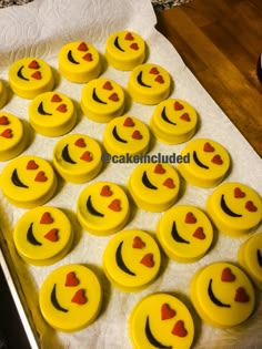 some yellow cupcakes with faces and hearts on them