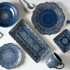 blue and white dinnerware set on table with utensils