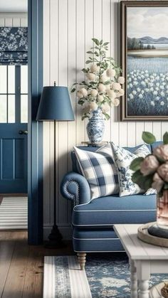 a blue and white living room with flowers on the coffee table in front of it