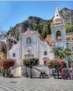 an old church in the middle of town with flowers growing out of it's windows