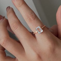 a woman's hand with a ring on it and an aqua blue topazte