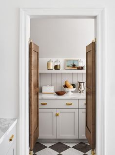 an open door leading to a kitchen with white cabinets