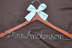 a wooden hanger with a bow on it that says, mom and me in white