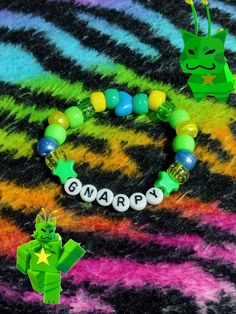 a green dragon bracelet with name beads and an origami star on the bead