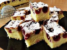 several pieces of cake sitting on top of a black plate