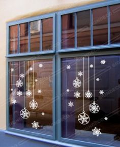 the window is decorated with snowflakes and ornaments