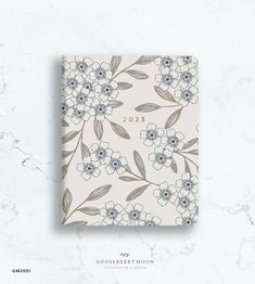 a white and blue flowered notebook with the year 2013 on it's cover