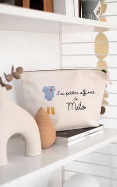 a white bag sitting on top of a book shelf next to a stuffed animal toy