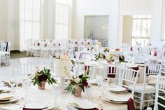 the tables are set with white linens and red napkins for an elegant wedding reception