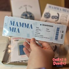 a person is holding up a ticket for a performance in mamma mia, the musical