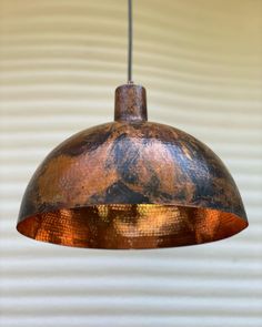 a copper colored light hanging from a ceiling