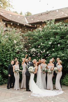 a group of people standing next to each other in front of a building with flowers