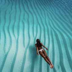 a woman is floating in the water on her stomach