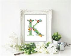 the letter k is made up of flowers and leaves in front of a white frame