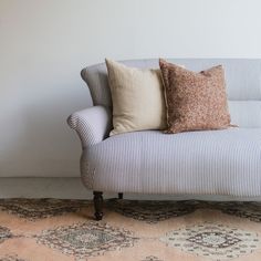 a blue and white striped couch sitting on top of a rug next to a wall