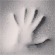 a black and white photo of a hand in the snow with its fingers extended out