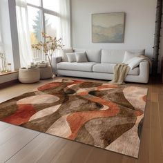 a living room with a couch and rug on the floor in front of a large window