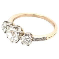 an antique three stone diamond ring with two diamonds on the sides and four stones in the middle