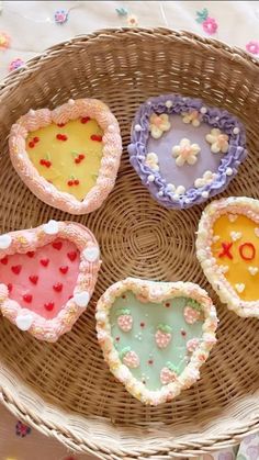 four heart shaped cookies sitting on top of a wicker basket