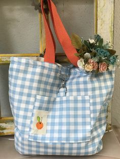 a blue and white gingham tote bag with an apple patch on the front