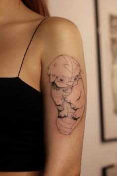 a woman's arm with a small tattoo of an otter and her baby on it