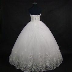 a white wedding dress is displayed on a mannequin