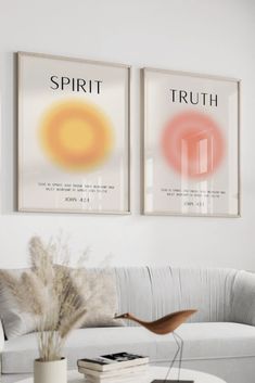 two posters on the wall above a couch in a living room with a coffee table