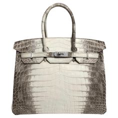 Up for sale is the Holy Grail Hermès Birkin 35 Diamond Himalayan. The Diamond Himalyan is the pinnacle of luxury and elegance, celebrated as one of the rarest and most exquisite handbags in the world. Crafted from Niloticus crocodile leather, the bag features a color gradient that ranges from a rich smoky gray to a pearly white, reminiscent of the majestic Himalayas, which inspired its name. What elevates this Birkin to a level of pure opulence is the dazzling hardware: the clasp, lock, and key are crafted from 18-karat white gold, and are adorned with sparkling, flawless diamonds. The combination of radiant diamonds set against the refined gradient of the leather makes this handbag a true masterpiece. With only a few pieces made every year the Diamond Himalayan Birkin is more than just a Most Expensive Hermes Bag, Hermes Ostrich Birkin, Himalayan Birkin, Rich Bags, Hermes Crocodile Bag, Status Symbol, Hermes Birkin 35, Flawless Diamond, Crocodile Bags