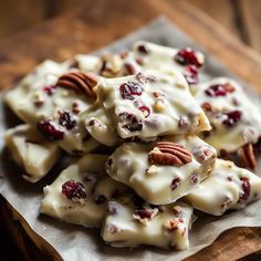 a pile of white chocolate with pecans and cranberries