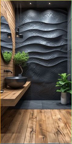 a bathroom with wood flooring and black stone wall covering the bathtub is surrounded by greenery