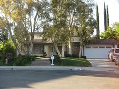 a house with trees and bushes in front of it