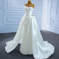 a white wedding dress on display in a room