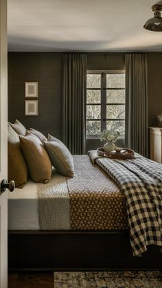 a bed sitting in a bedroom under a window next to a wooden dresser and lamp