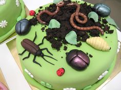 a green cake with bugs, ladybugs and grasshoppers on it