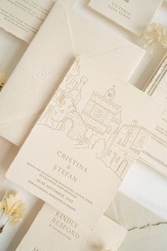 the wedding stationery is laid out on top of each other, with white flowers