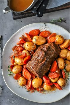 a white plate topped with meat and potatoes