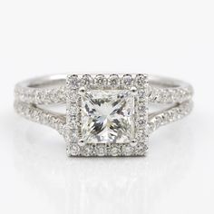 an engagement ring with a princess cut diamond in the center and pave diamonds around it