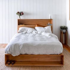 a bed with white sheets and pillows in a room