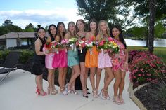 a group of young women standing next to each other holding bouquets in their hands